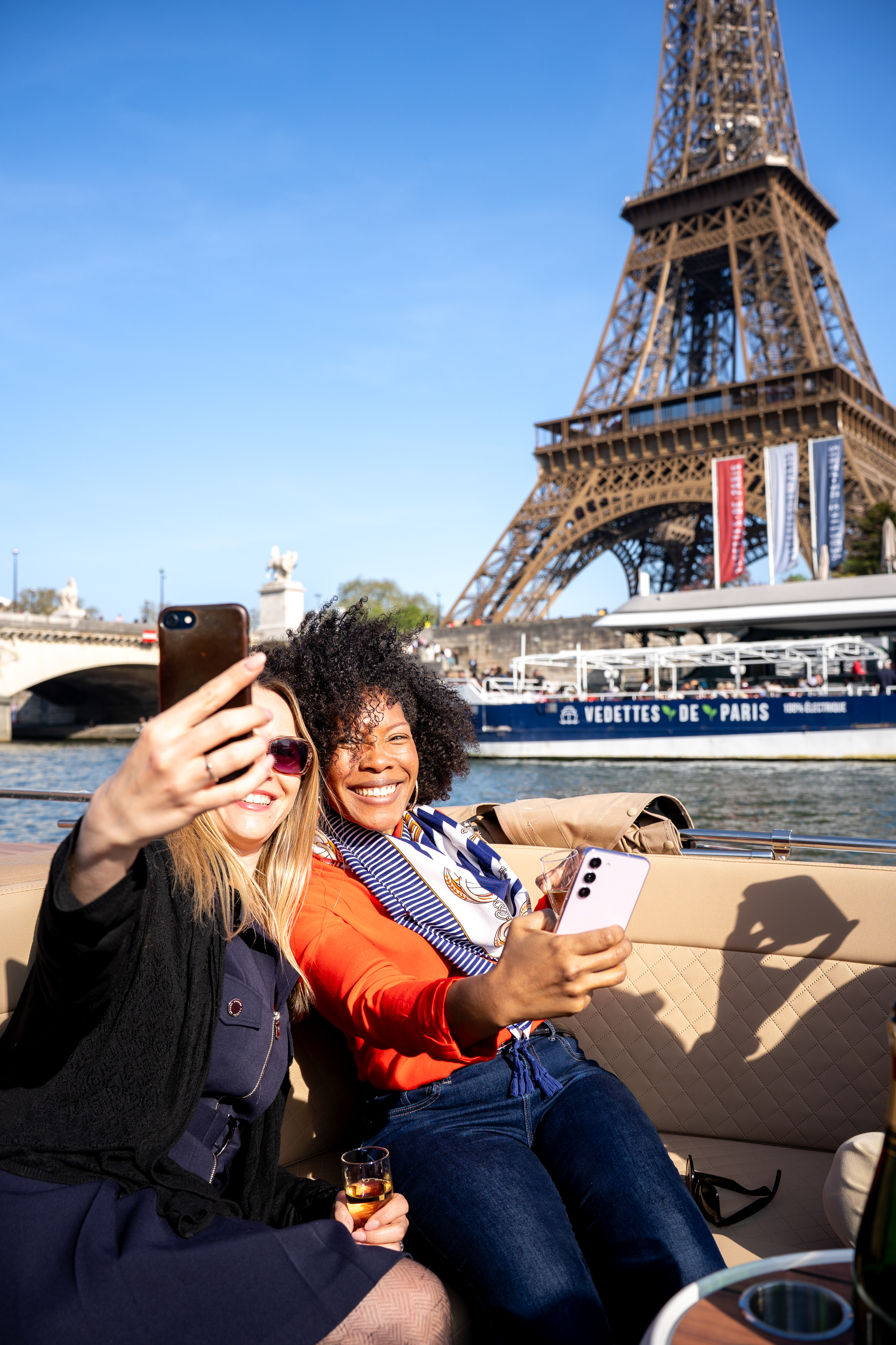 Two girls taking a selfie on a private boat tour with the Eiffel Tower in the background