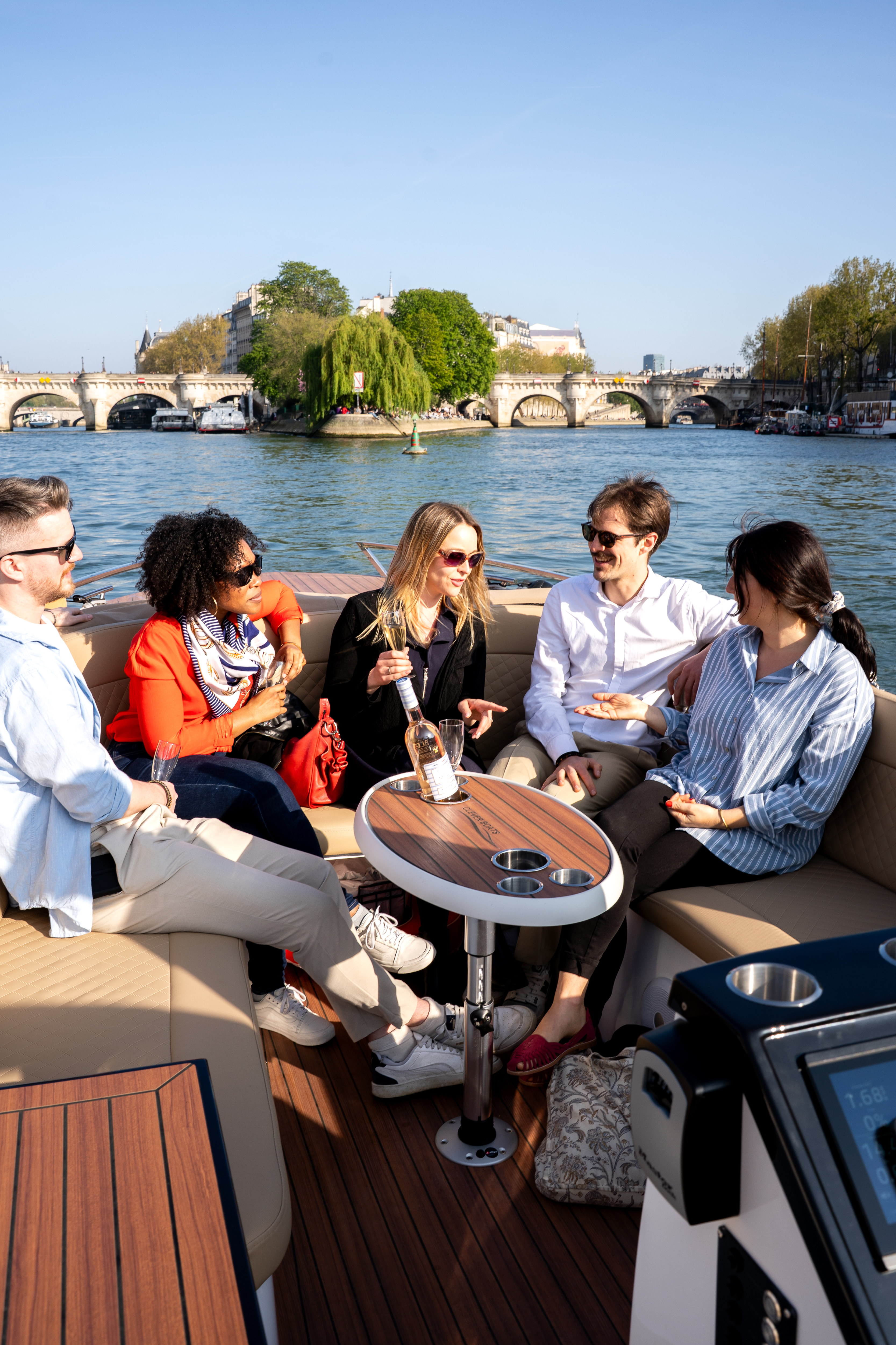 Private Boat Tour in Paris showing a group of people cheering in front of the Eiffel Tower on the Seine River